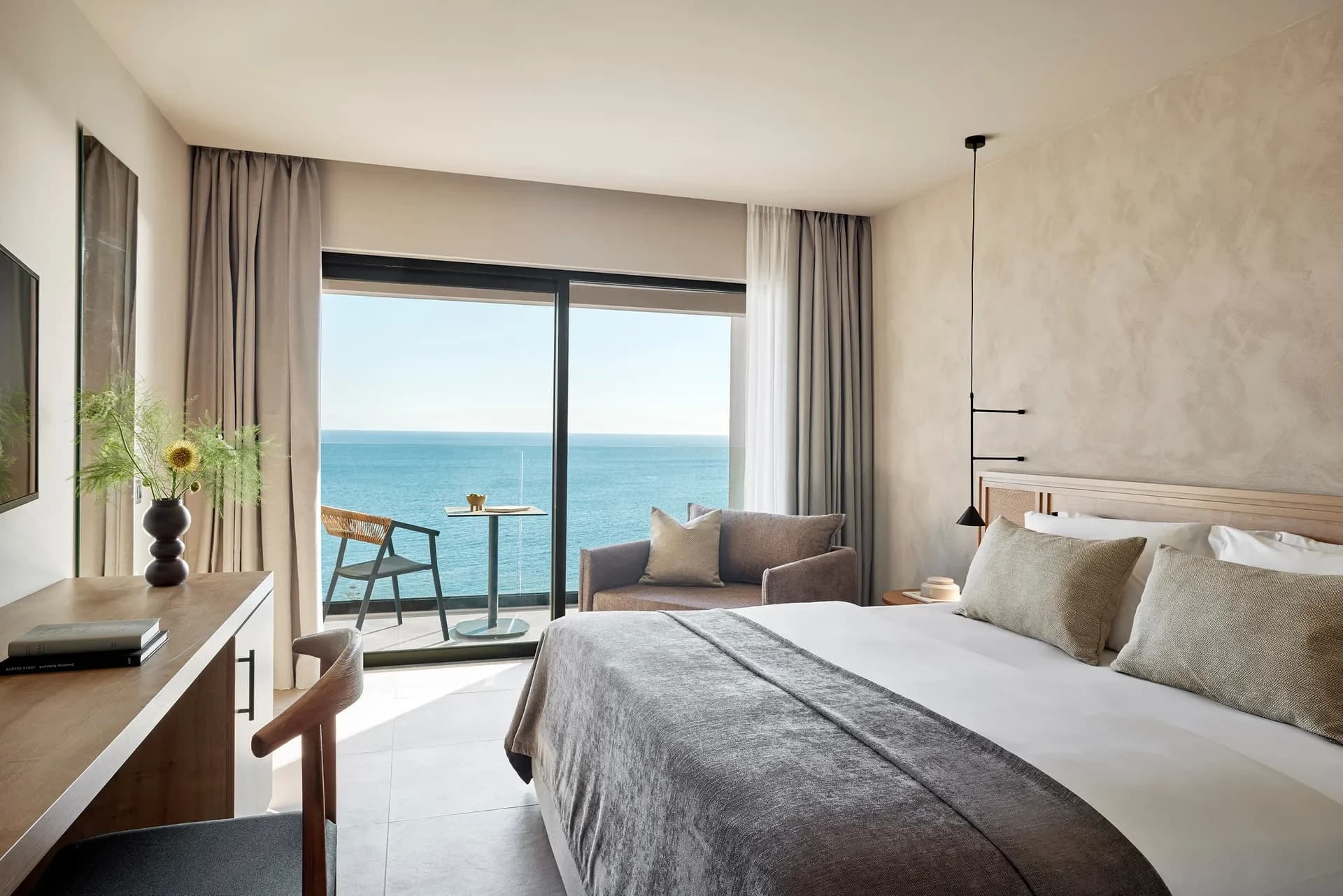 Hotel guest room with sea view, crisp bed linen, and curtains